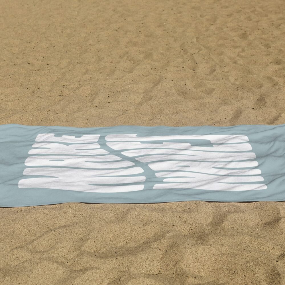 white beach towel psd mockup laying on the sand